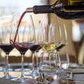 a glass of wine in the farm background with many bottles without brand